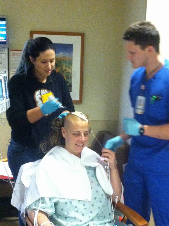 Daughter shaving my head under the supervision of the lead nurse in the NICU.